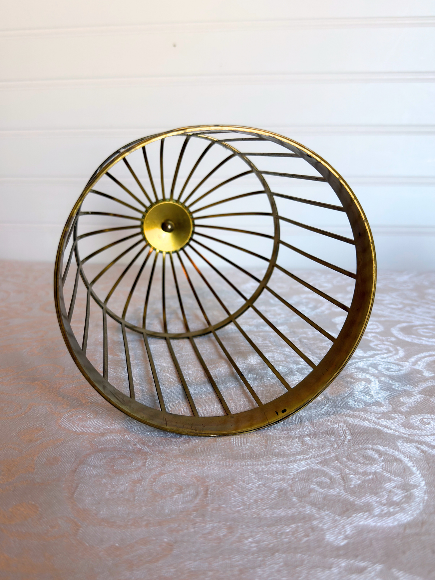 bottom of decorative bird cage on a white textured surface