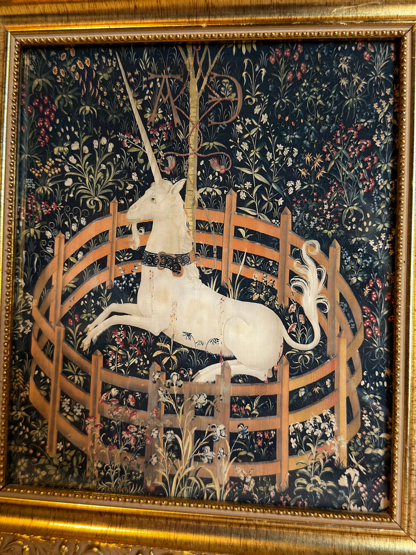 Decorative tapestry print with a unicorn in a gold frame on a white background