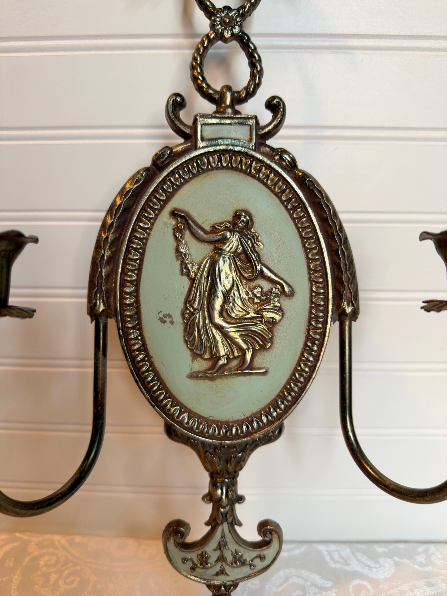 close up Decorative metal wall sconce with figurative lady design on a white background