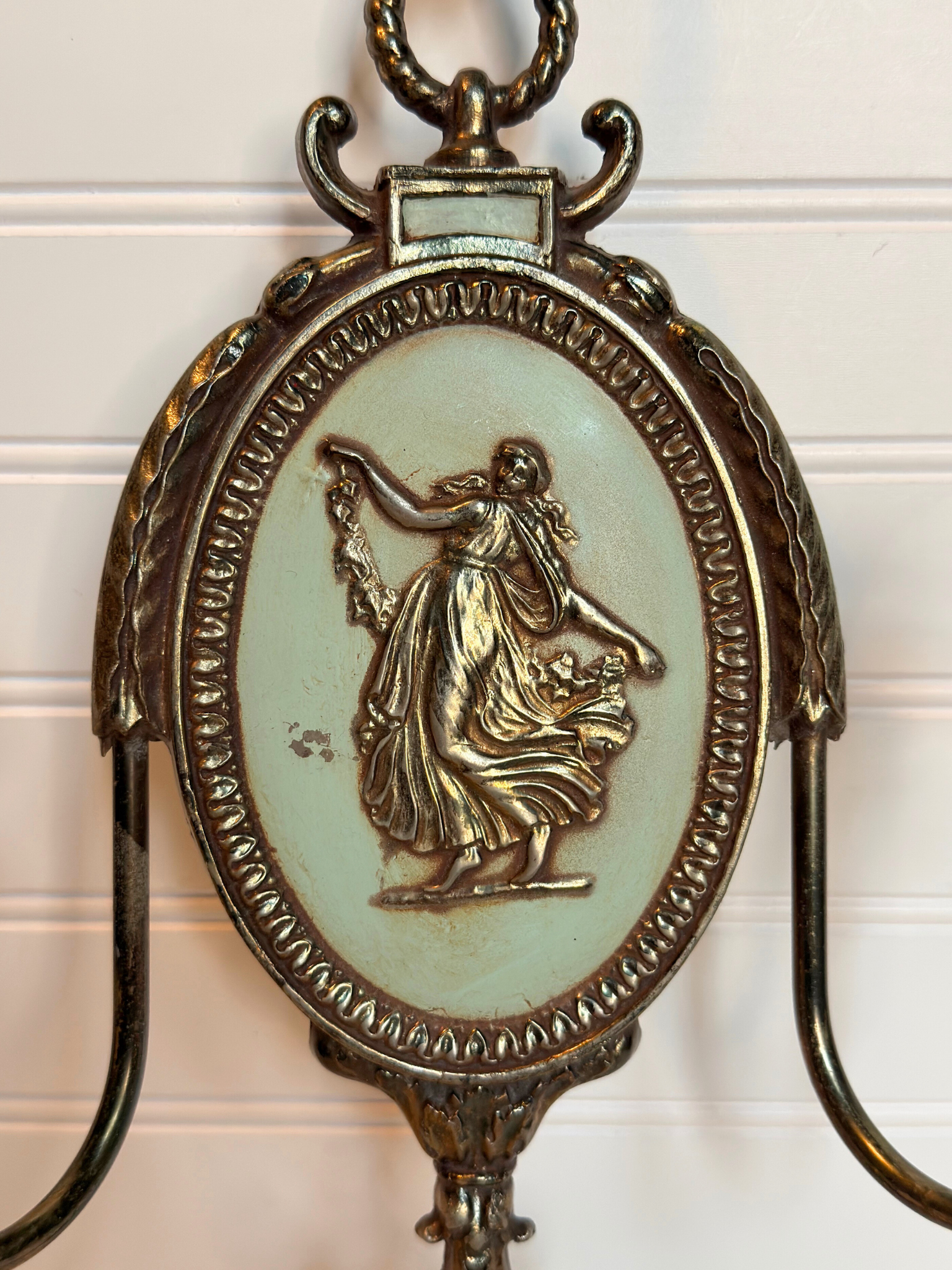 close up Decorative metal wall sconce with figurative lady design on a white background