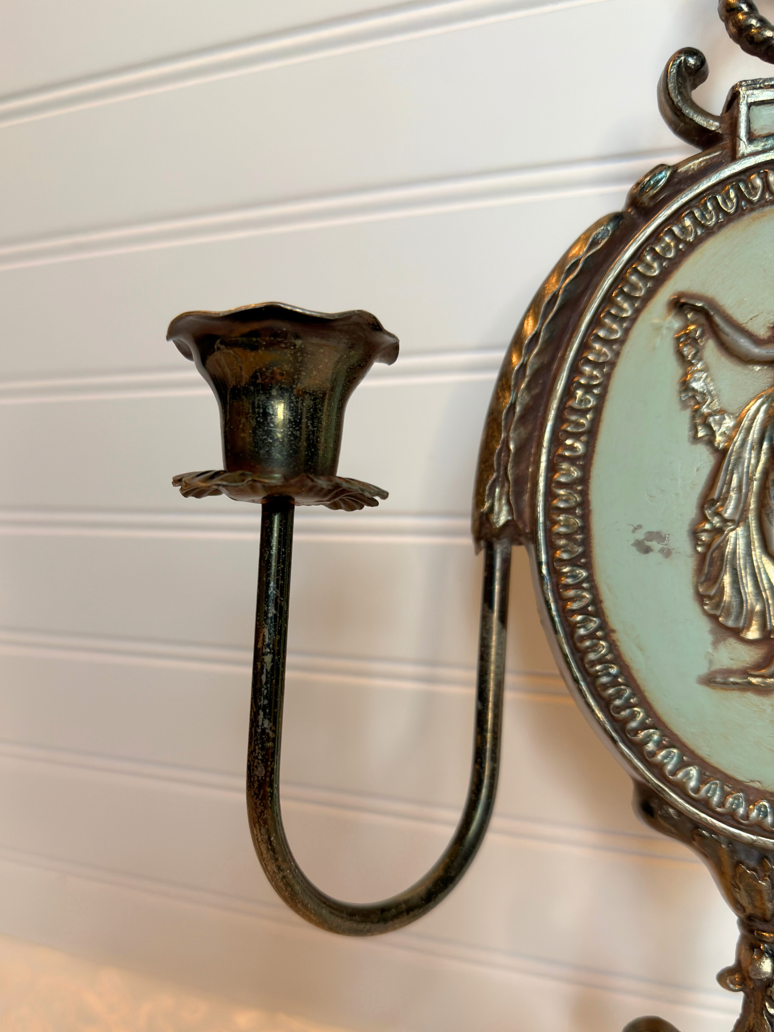 close up Decorative metal wall sconce with figurative lady design on a white background