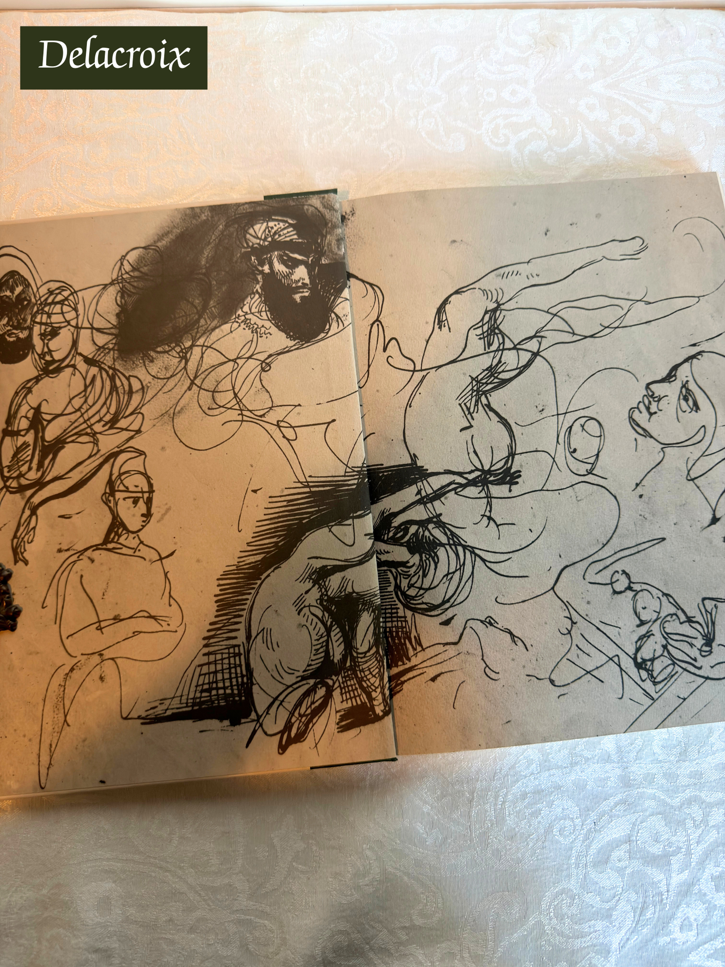 Artistic sketches of figures on a textured surface with 'Delacroix' branding.