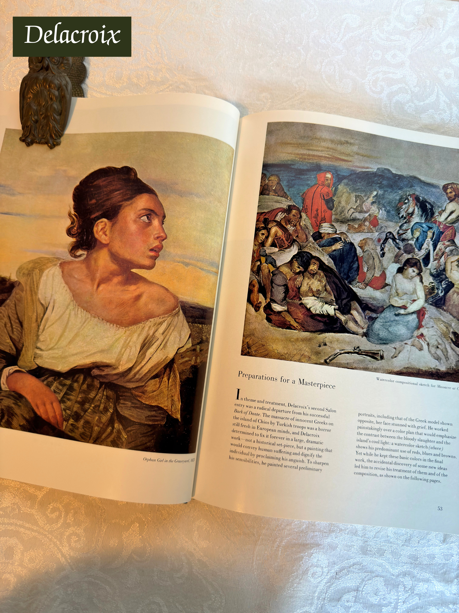 Open book showing Delacroix paintings with a decorative background