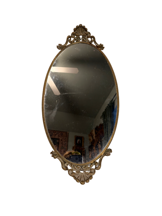 Decorative oval mirror with ornate frame on a white background