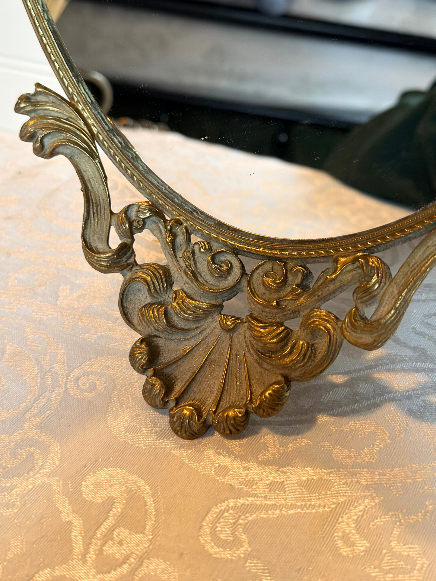 Decorative gold mirror with intricate designs on a textured surface