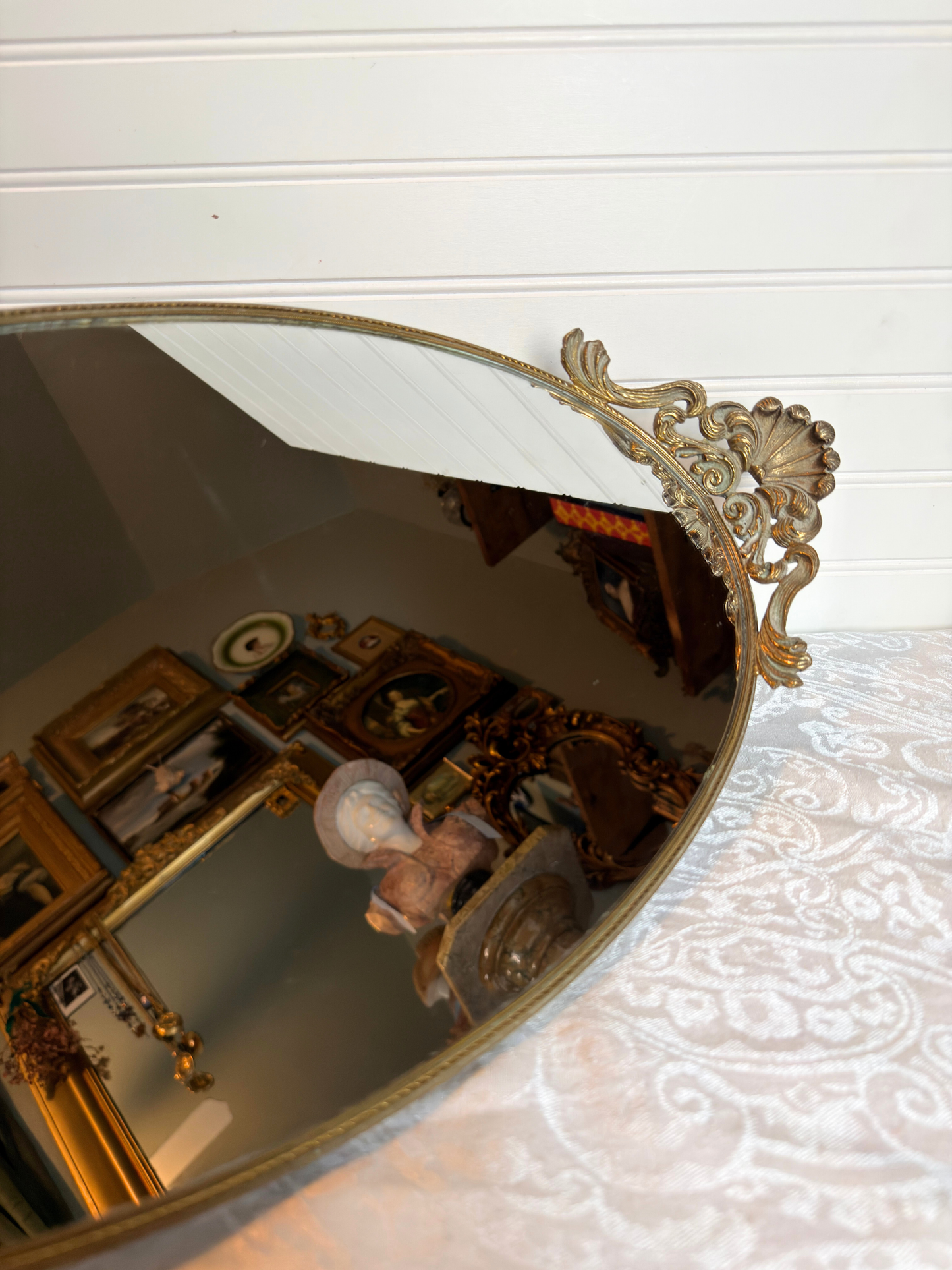 Decorative mirror with gold frame on a textured white surface