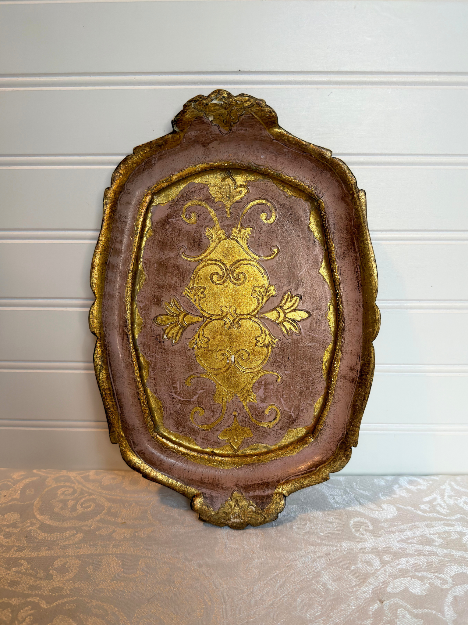 decorative pink and gold wood tray on a white background
