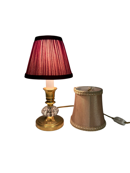 Table lamp with a Burgundy pleated shade and decorative base on a white background