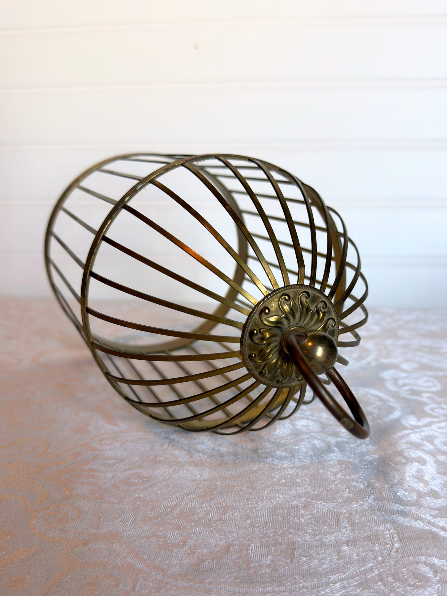 top of decorative brass cage on a textured surface