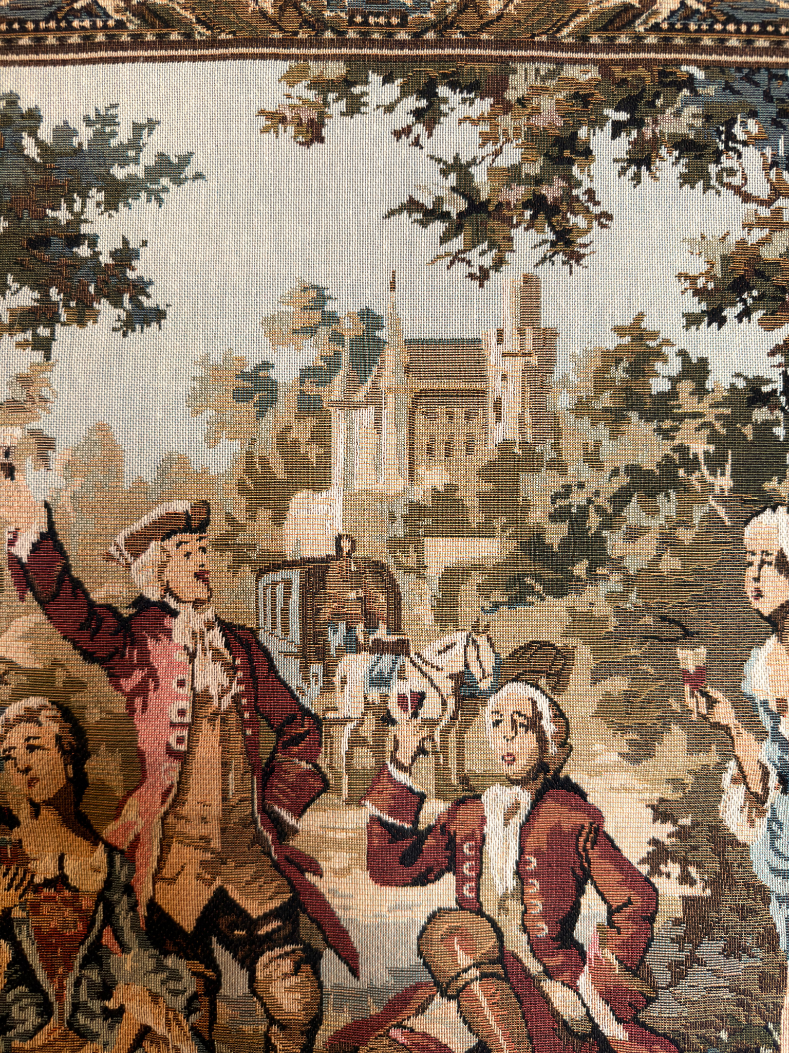 Tapestry with classical scene of people in formal attire with a castle in the background