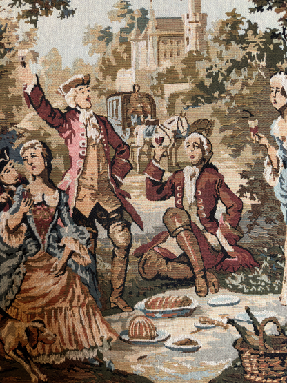 Decorative tapestry with classical scene of people in formal attire in a garden setting.