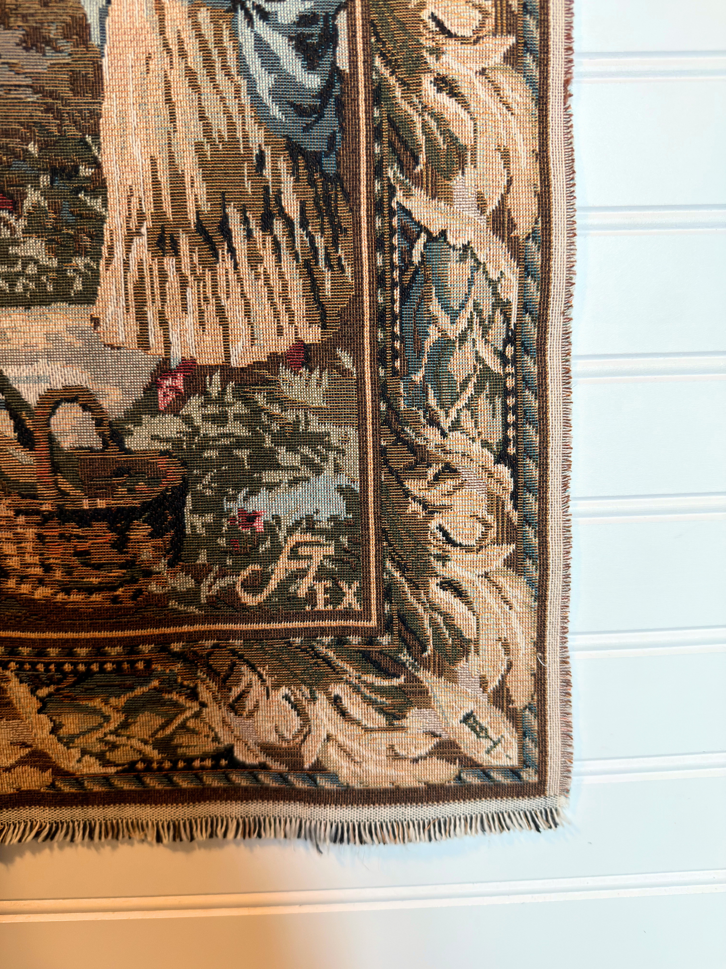 Decorative tapestry with intricate patterns and a brand logo on a white background