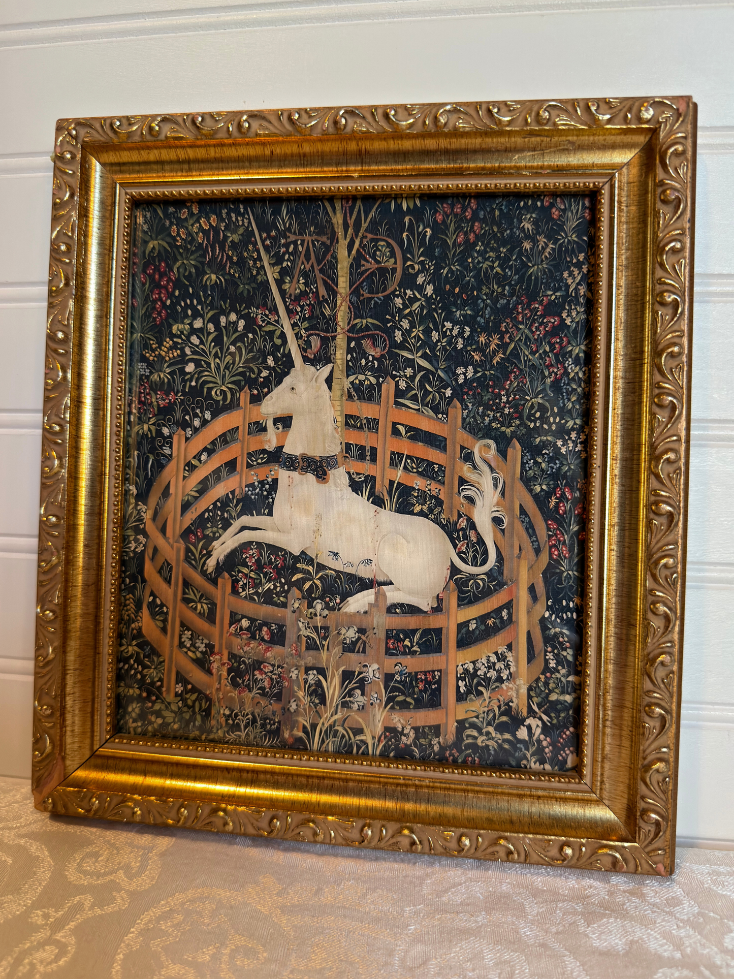Decorative tapestry print with a unicorn in a gold frame on a white background