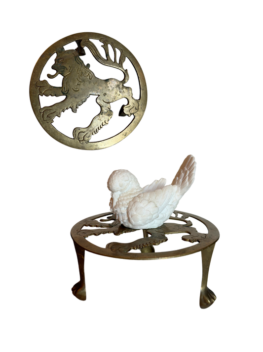Decorative brass stand with a bird figure on a white background