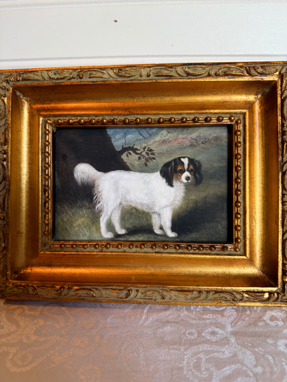 Small print of a white and black King Charles spaniel in a decorative gold frame on a white background