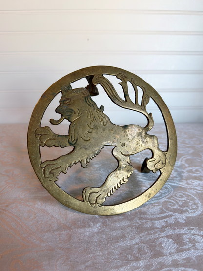 top of brass stand with lion design on textured surface