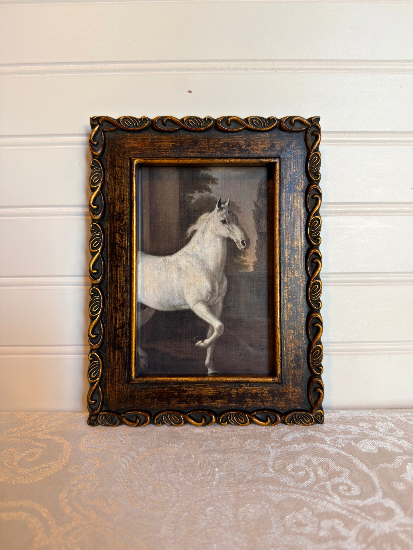 Framed print of a white horse in a bronze frame on a white background
