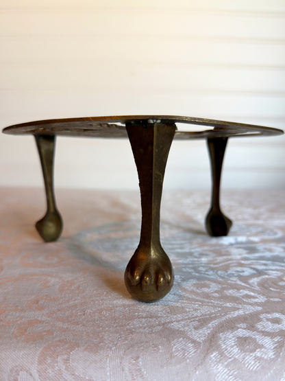 feet of brass stand on textured surface 