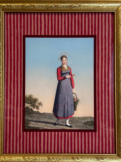 Framed artwork of a woman in a dress holding a basket on a red striped background