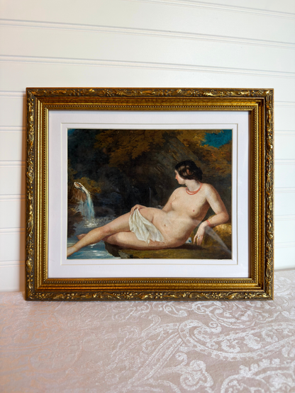 Framed print of a nude woman by a waterfall with a gold frame.