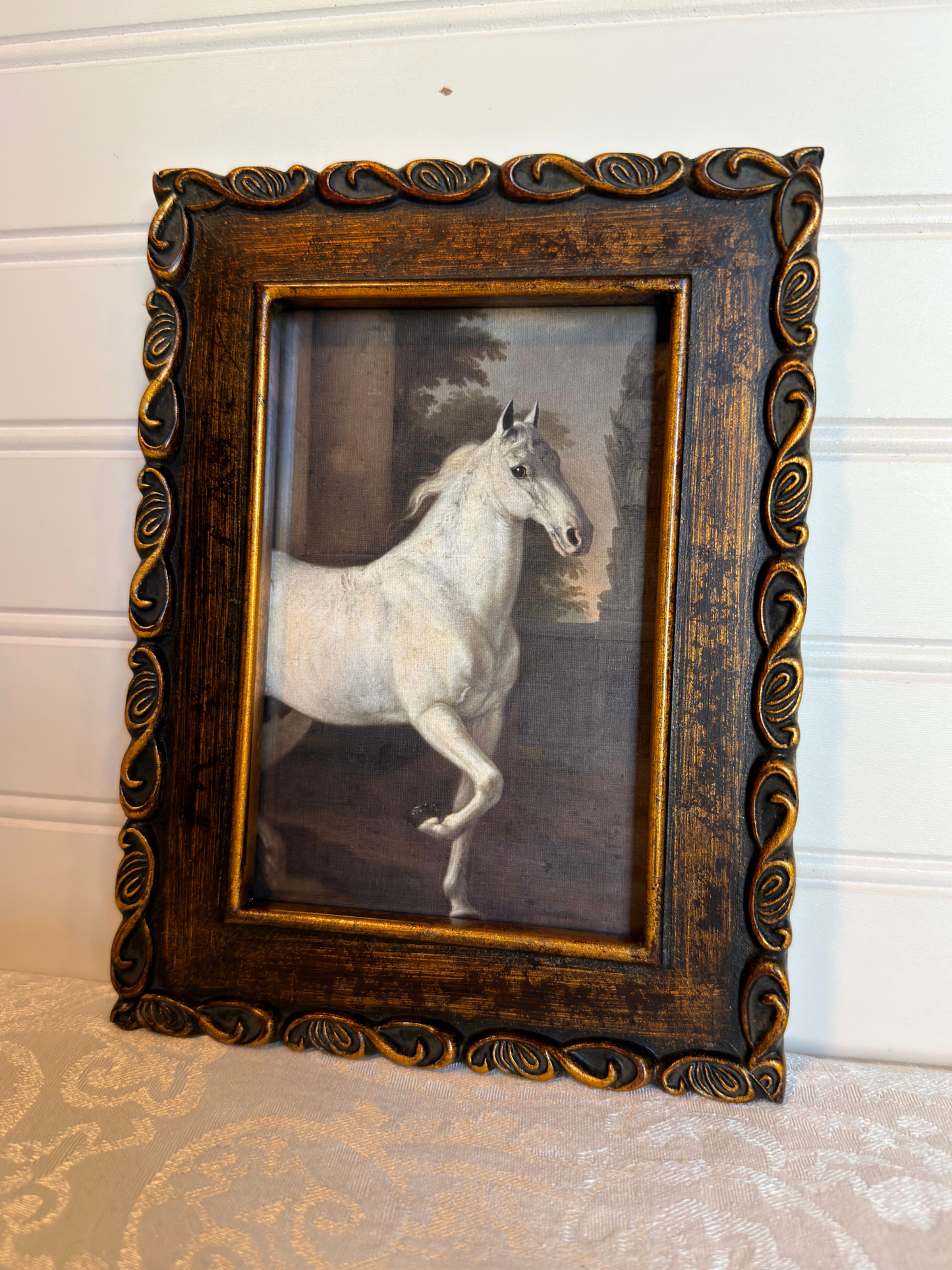 Framed print of a white horse in a bronze frame on a white background