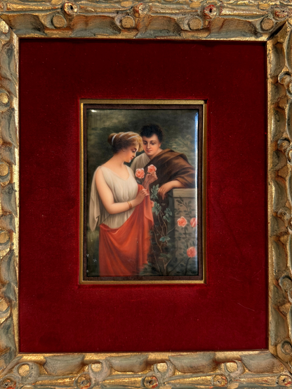 Small painting of couple with roses  within a decorative gold frame on a red background