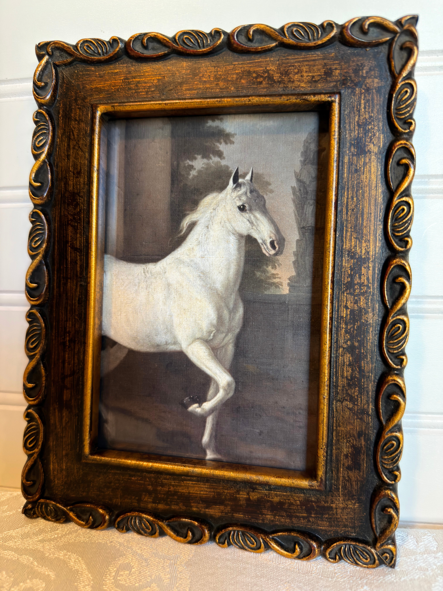 Framed print of a white horse in a bronze frame on a white background