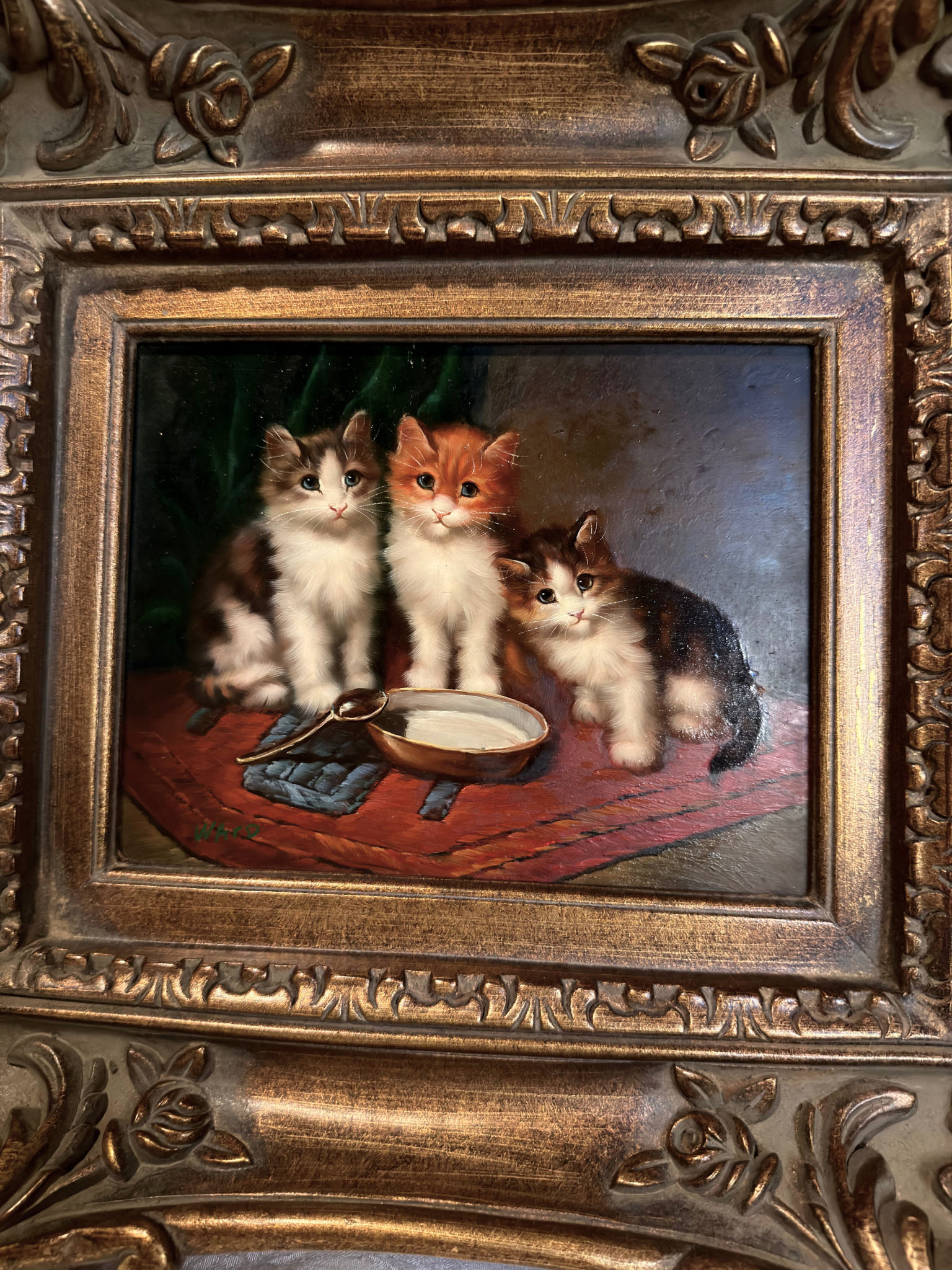 Oil painting of three kittens around a bowl in an ornate gold frame.