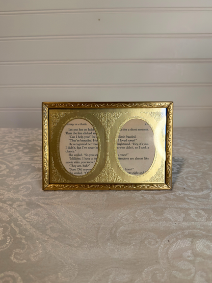 Gold-framed double oval frame with  text on a white background