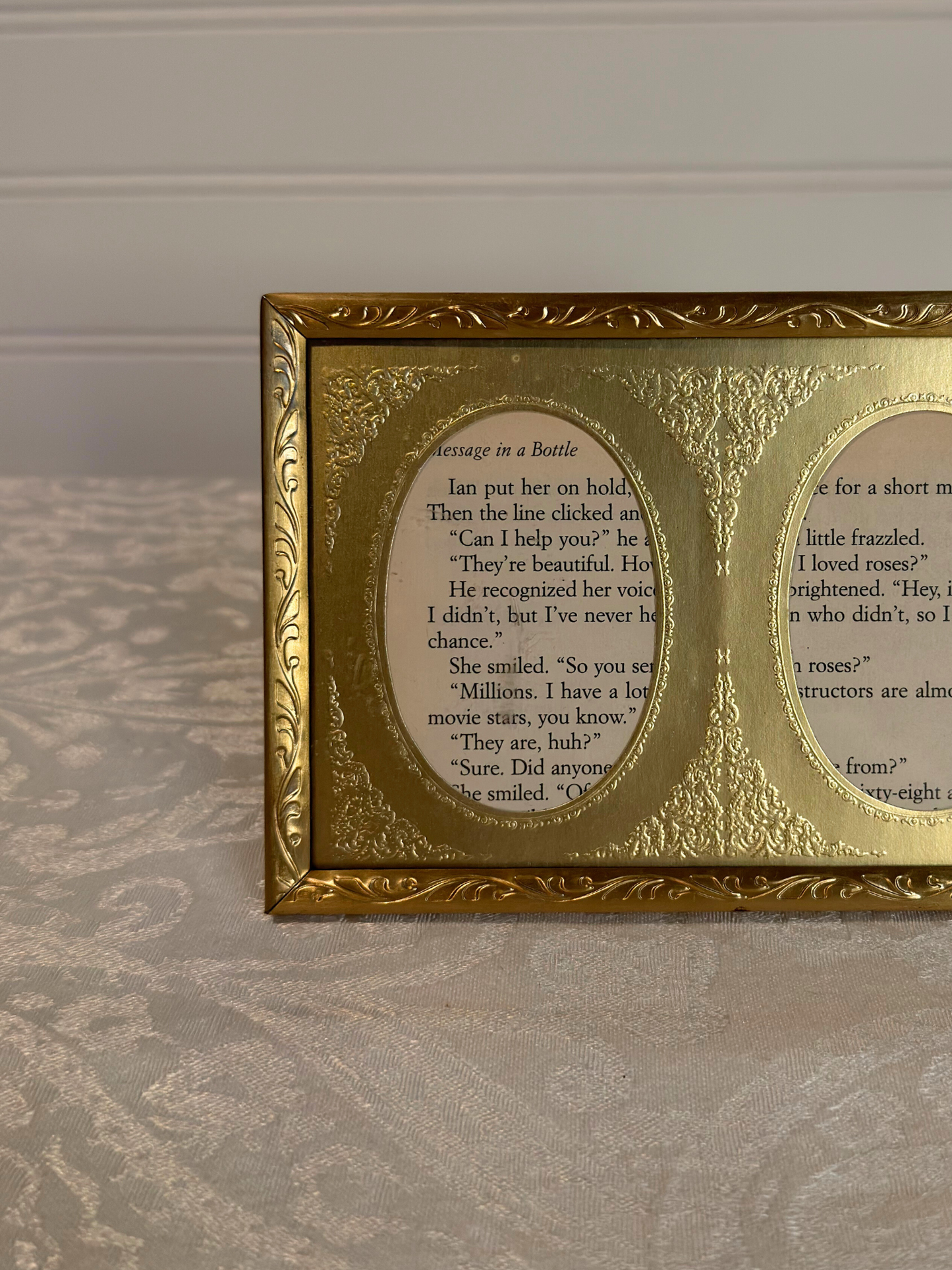 Gold-framed double oval frame with  text on a white background