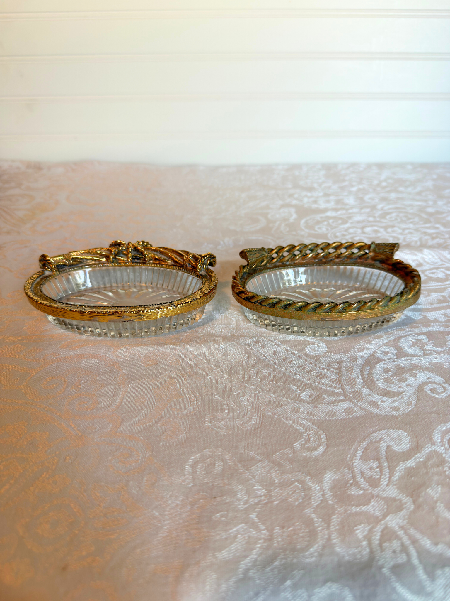 two decorative glass dish with gold rim on a textured white background