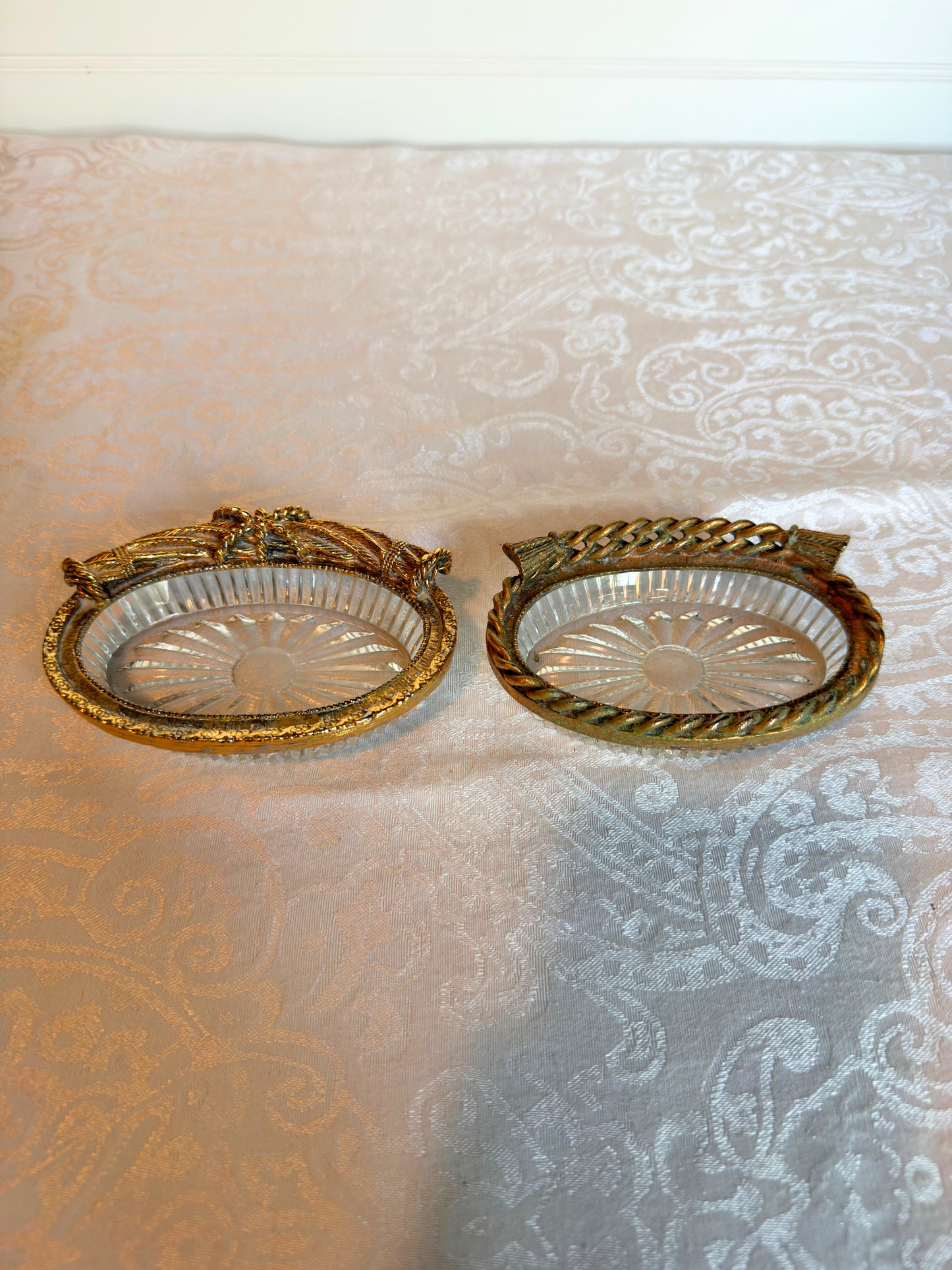 two decorative glass dish with gold rim on a textured white background
