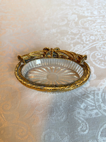Decorative glass dish with gold rim on a textured white background