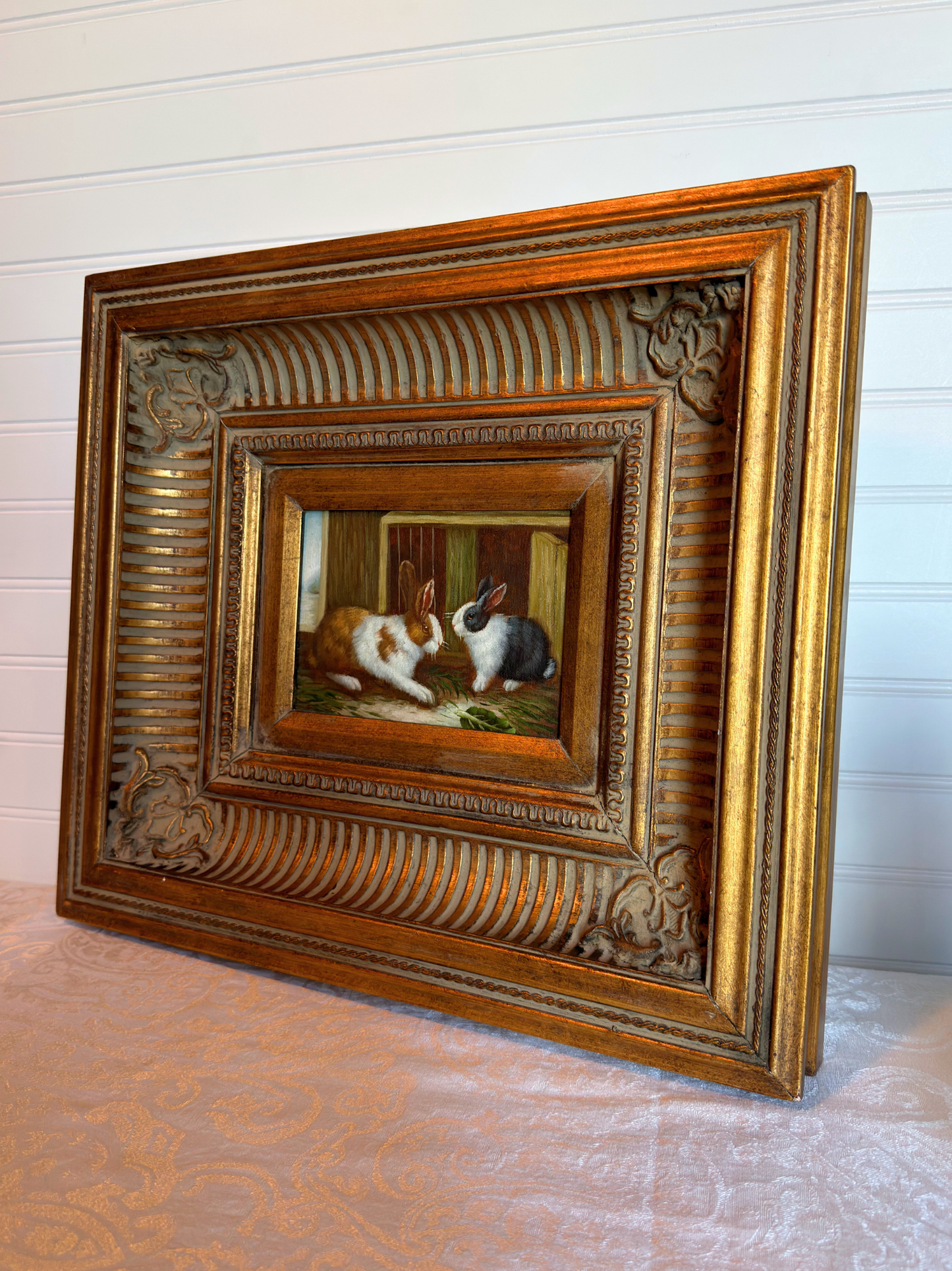Decorative framed painting of two rabbits on a textured surface with a white background