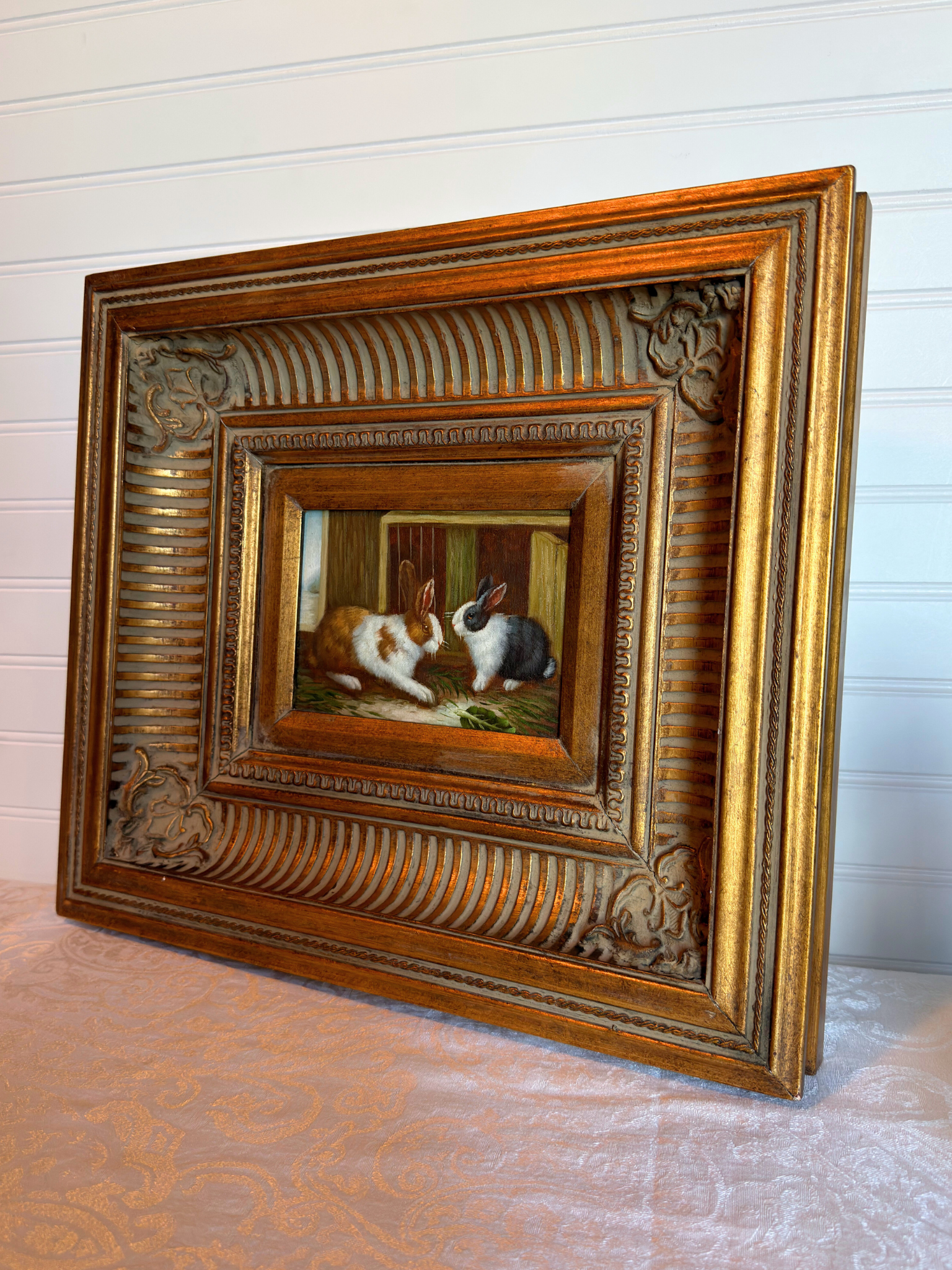 Decorative framed painting of two rabbits on a textured surface with a white background