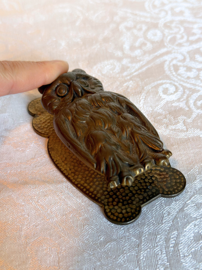 owl hand clip held in a hand against a white background