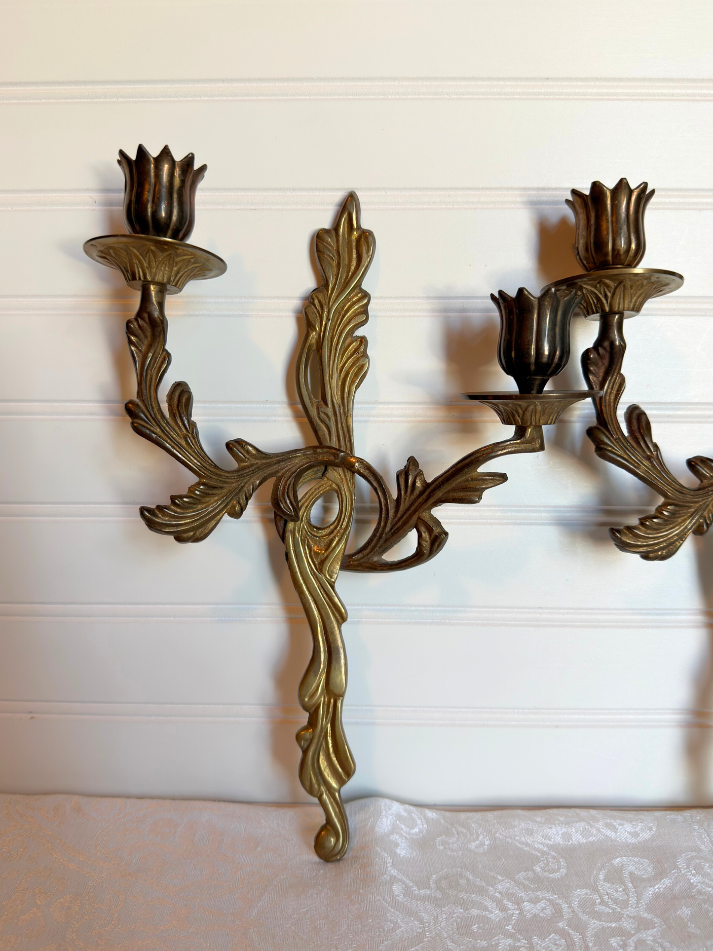 ornate brass wall sconce on a white background