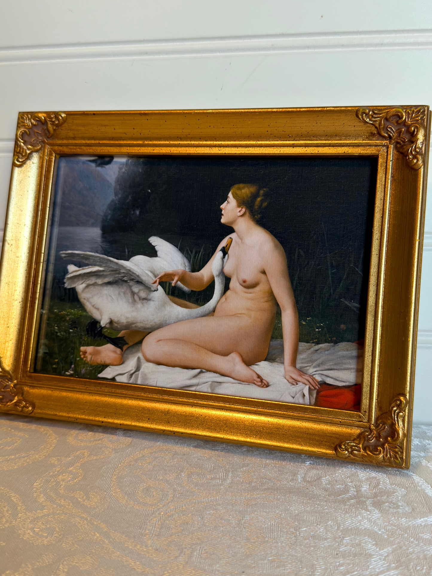 print of nude lady and a swan  in a gold frame on a white background