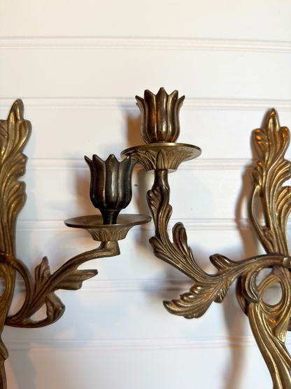 close up of ornate brass wall sconces on a white background