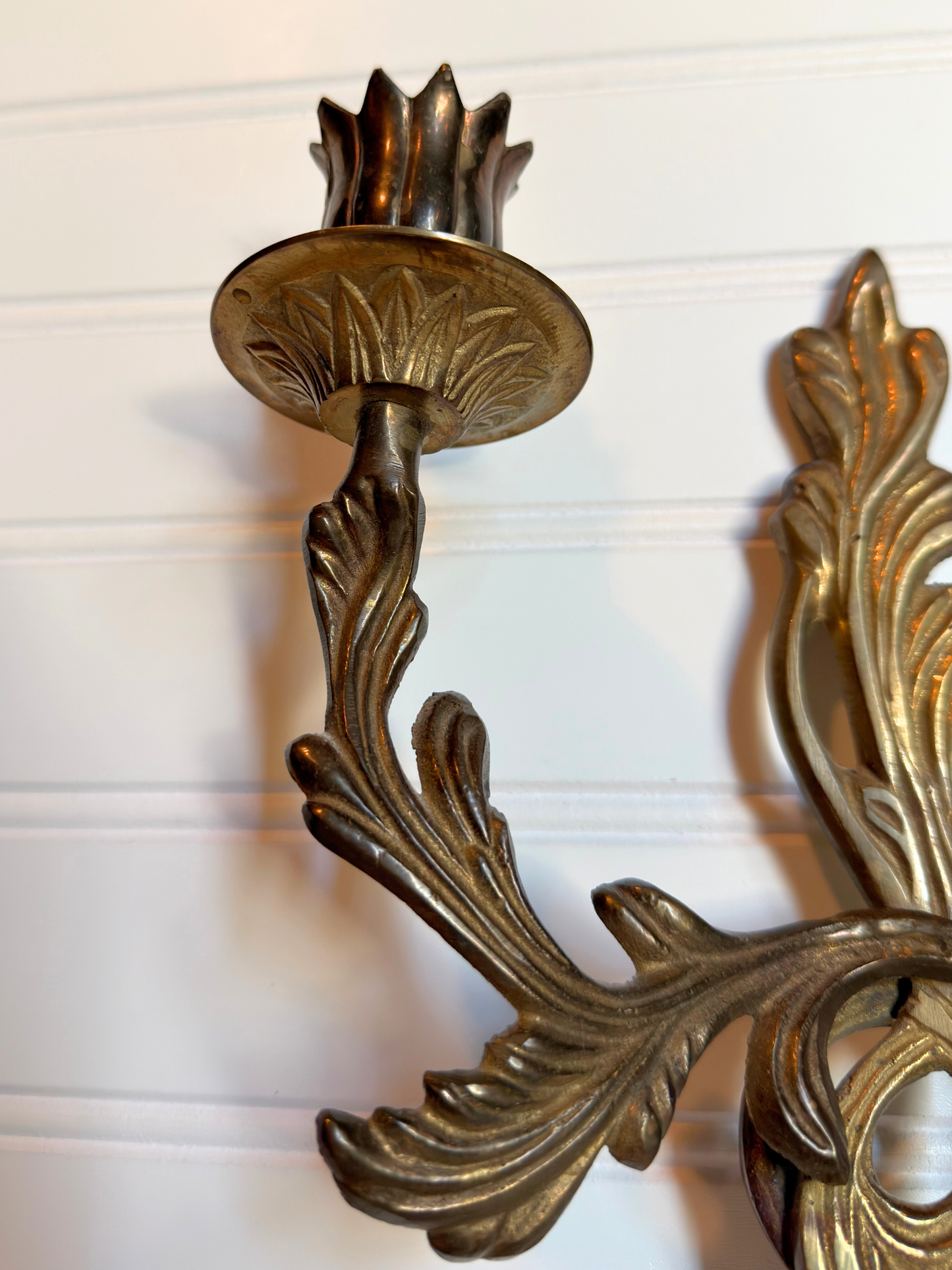 close up of ornate brass wall sconces on a white background