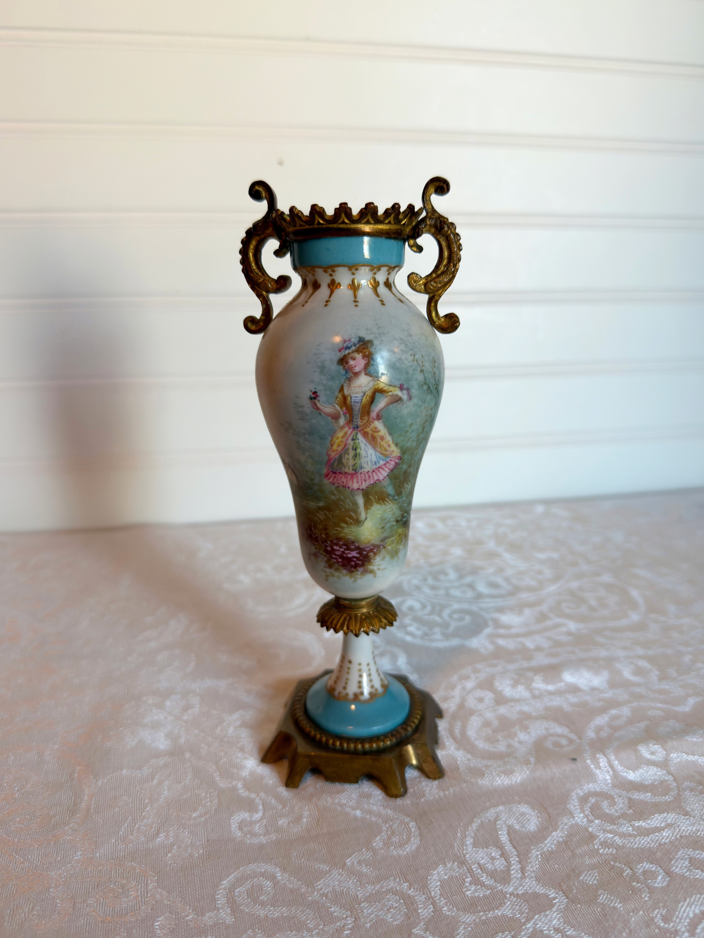 Decorative porcelain and bronze  vase with a painted lady on a white background