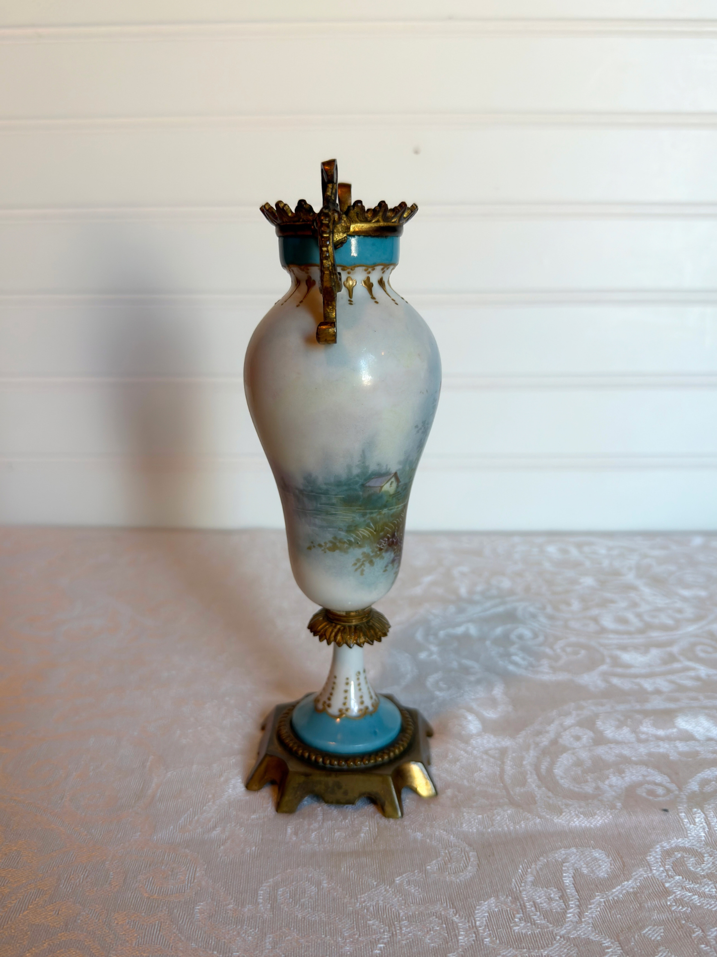 Decorative porcelain and bronze  vase with a painted house on a white background