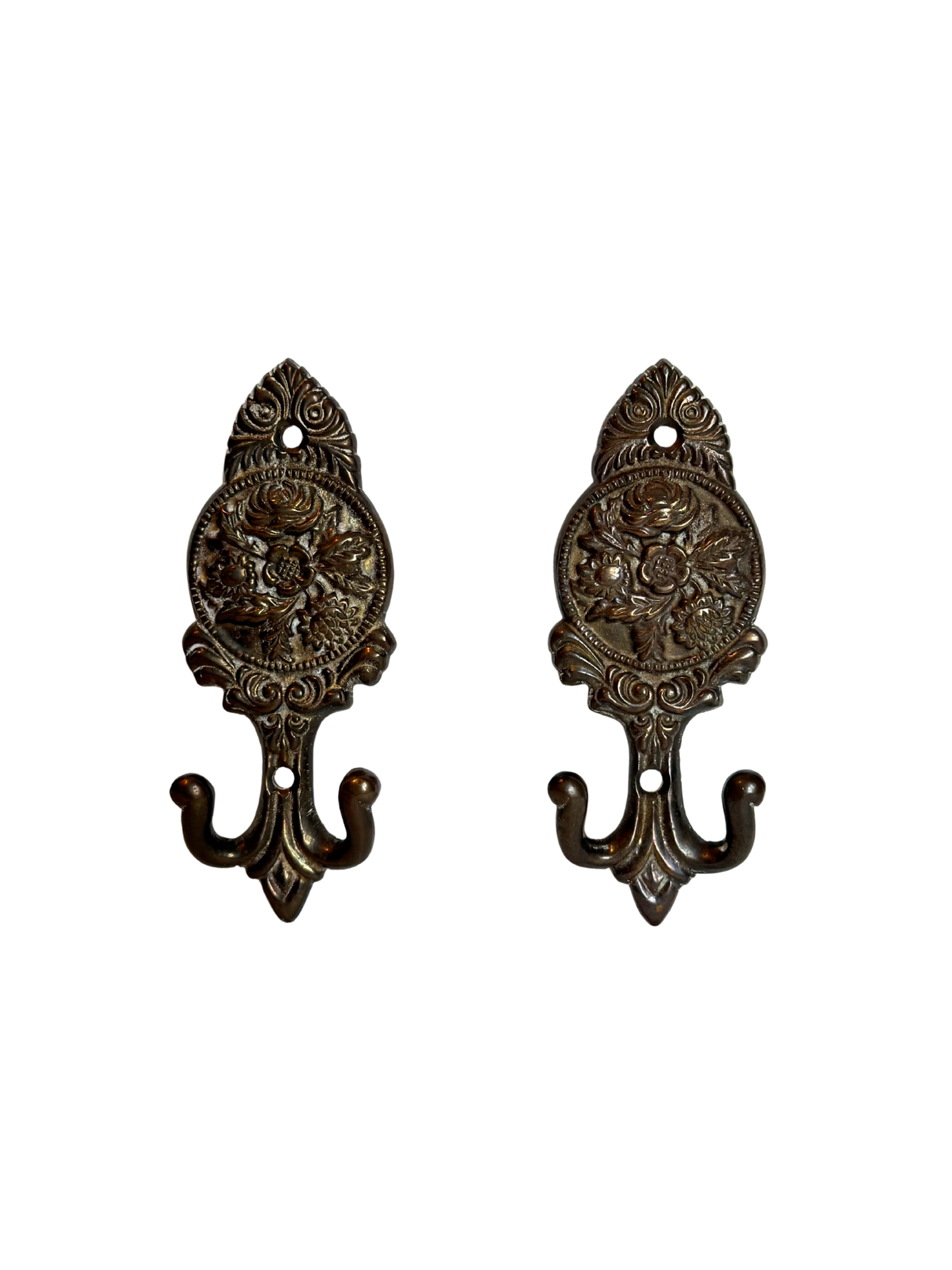Pair of ornate brass floral wall hooks on a white background