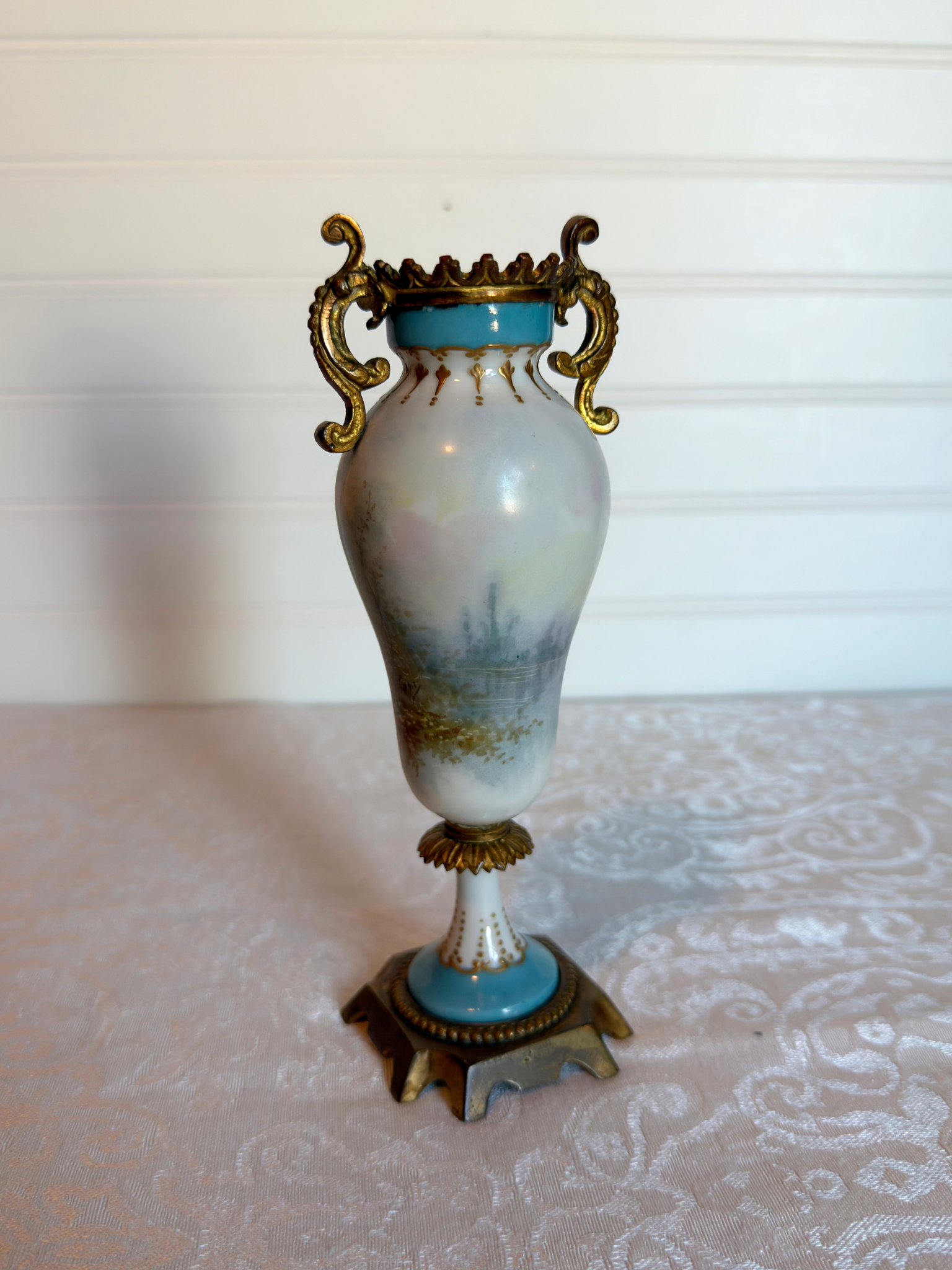 Decorative porcelain and bronze  vase with a painted trees  on a white background