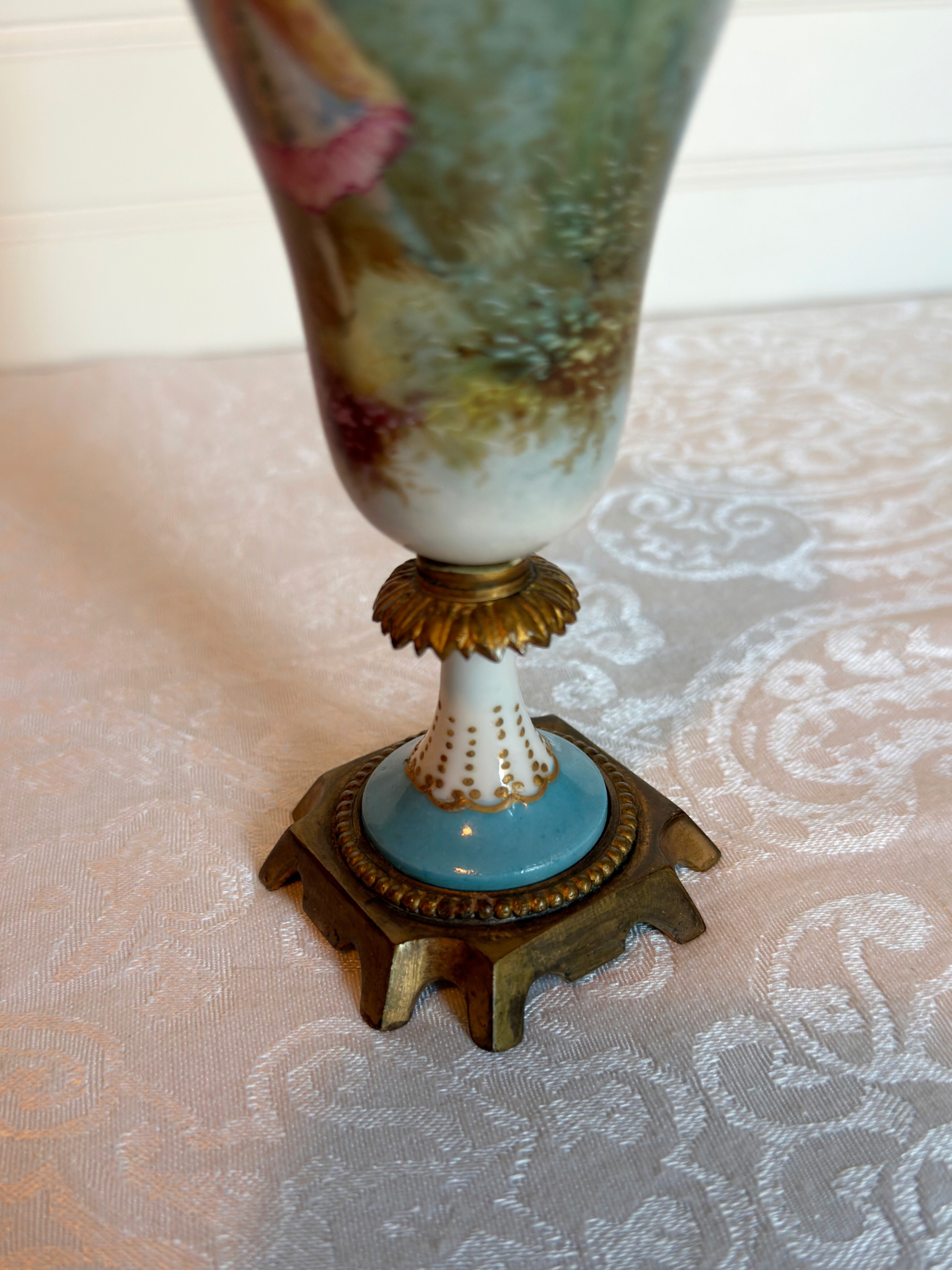 Decorative vase with a gold base on a patterned surface
