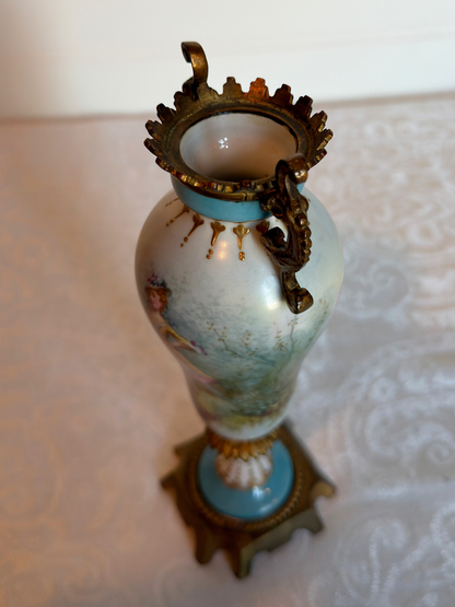 Decorative vase with ornate design and gold accents on a textured surface