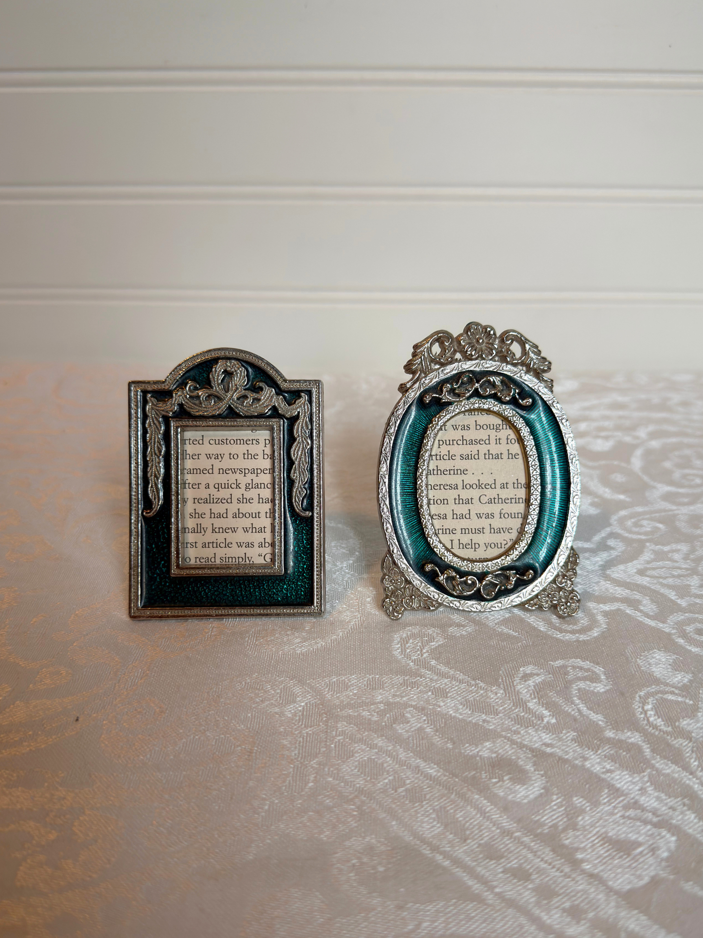Two decorative teal and silver mini frames with text inside on a white background