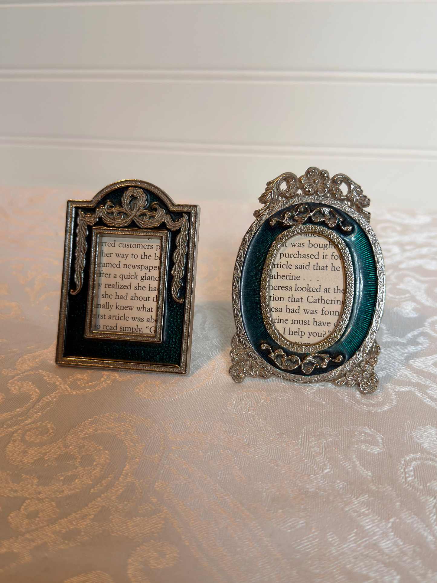 Two decorative teal and silver mini frames with text inside on a white background