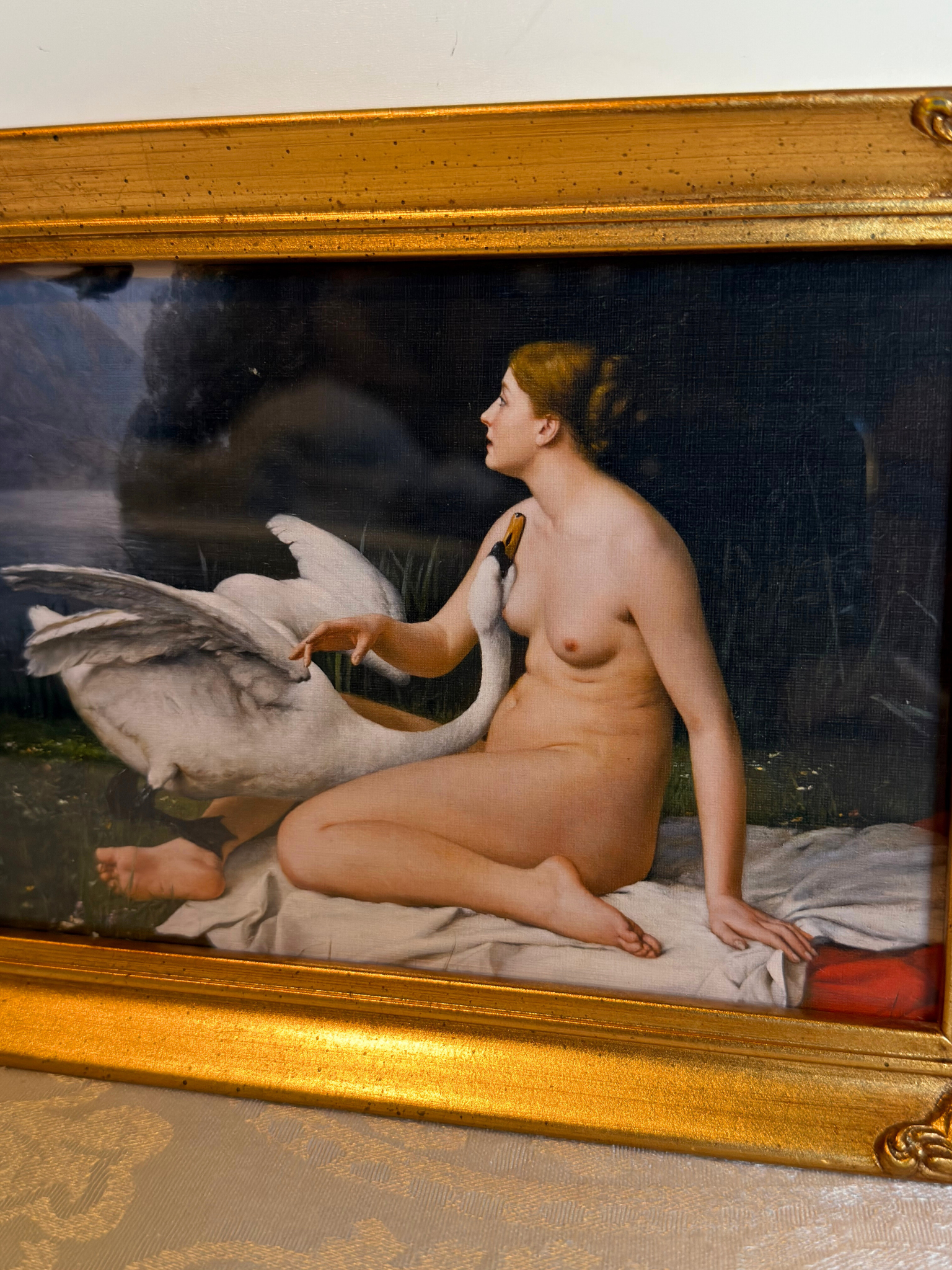 print of nude lady and a swan  in a gold frame on a white background